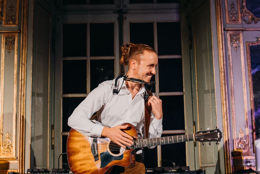 Aaron Wälchli mit Mundharmonika in der Villa Wenkenhof. Foto: Judit Maier.